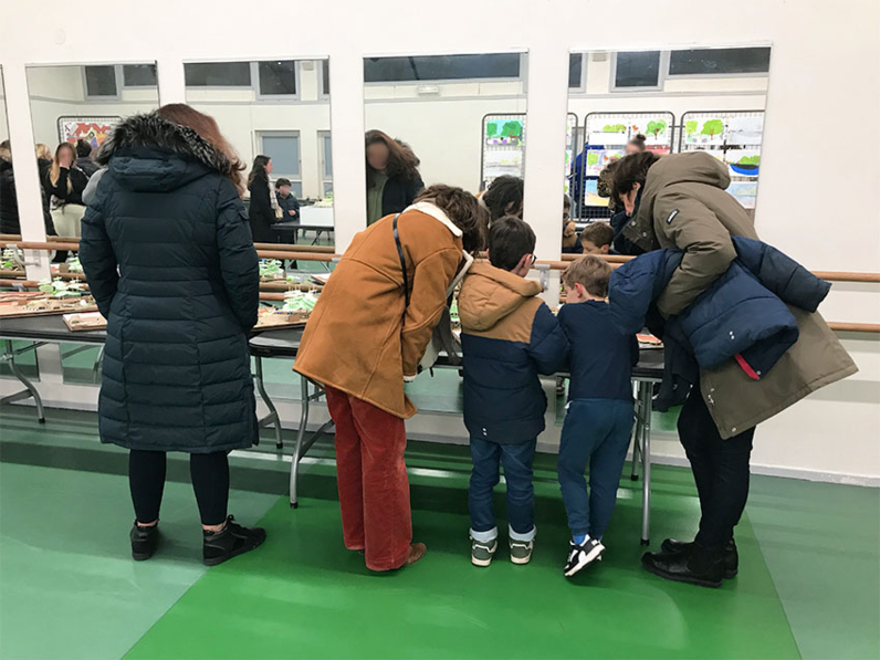 Les enfants expliquent leurs travaux aux parents.